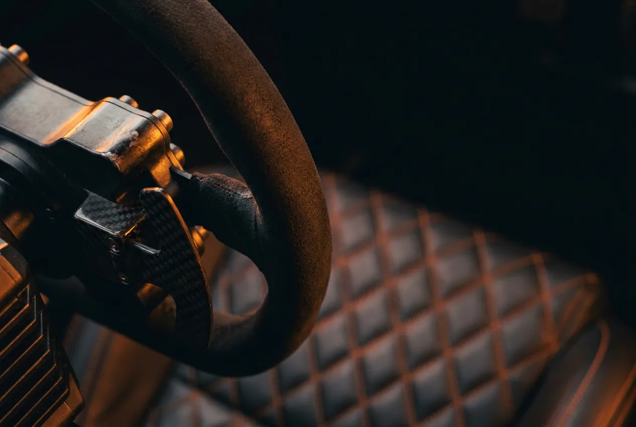 Macro detail of a direct-drive racing wheel with ember light on the rim